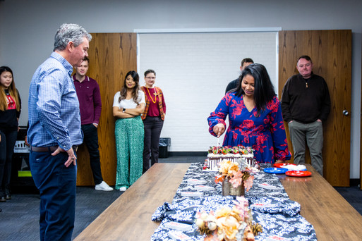 Staff watching a cake being cut